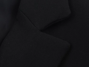 Detailed close-up of notch lapel and twill fabric texture on a black formal blazer jacket