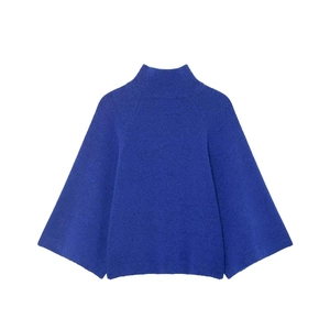 Detail view of Klein blue turtleneck sweater with wide flared sleeves in fuzzy texture