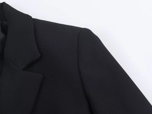 Detail of lapel and shoulder on black tailored blazer with high-quality woven fabric