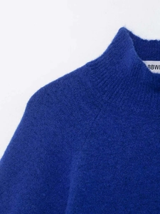 Detail of dark blue mock neck knit sweater showing fuzzy mohair texture and brand label