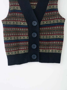 Detailed close-up of retro Fair Isle knit vest with V-neck and matte blue buttons
