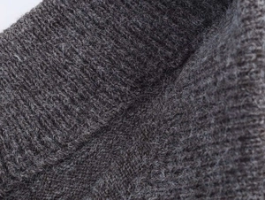 Vista macro de la textura de punto de cachemira gris oscuro acanalado con lana suave