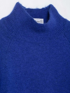 Detail view of the mock neck and soft textured fabric on this electric blue knit sweater