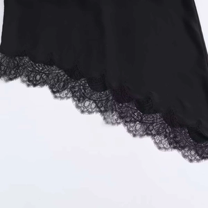 Détail de l'ourlet asymétrique avec dentelle noire raffinée sur tissu effet soie