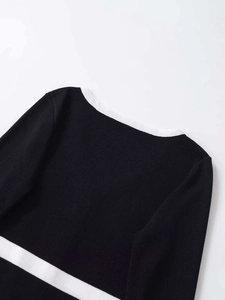 Detail of black knit cardigan with white contrast piping and high-quality fine texture