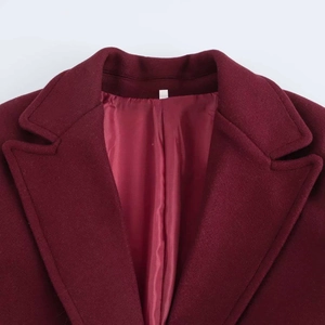 Detail of burgundy wool coat with a classic notched lapel and smooth inner lining