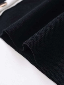 Close-up of high-density black ribbed knit fabric detailing on the cardigan sleeve