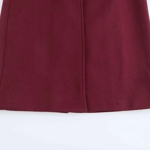 Detail of dark red wool coat showing precise stitching and heavy premium fabric texture