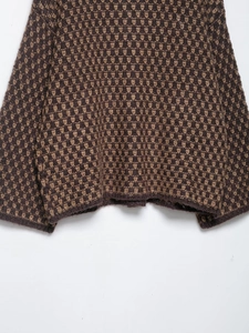 Detailed view of the brown and beige geometric triangle jacquard knit pattern fabric
