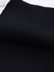 Macro detail of high-quality black knit fabric showing tight texture and premium weave