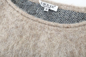 Detail of the soft mohair texture and neck label on this camel knitted sweater