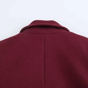 Close-up of stitching details on the back collar and shoulders of a burgundy wool coat