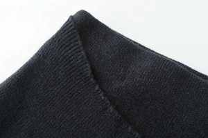 Detail of dark grey ribbed knit cuff showing elastic texture and fine stitching