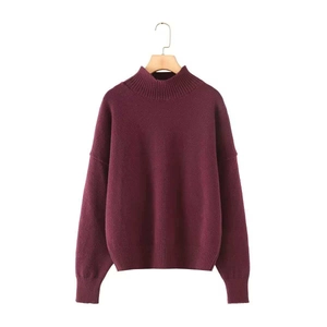 Close-up of deep wine red loose knit sweater with ribbed hem and high round neckline