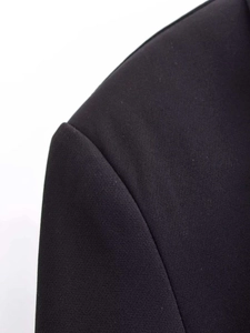 Detail of the shoulder stitching and woven texture on a black lace blazer dress