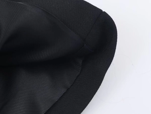 Close-up of black blazer cuff showing textured knit fabric and premium inner lining