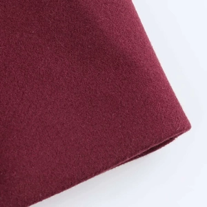 Close-up of premium deep burgundy wool fabric showing detailed texture and soft fiber finish