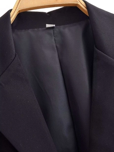 Close-up of black lace blazer dress with notched lapel and smooth satin lining details