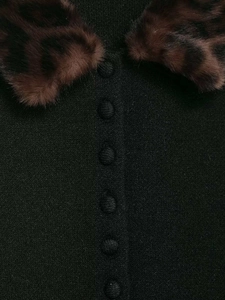Détail du cardigan en tricot noir avec col en fausse fourrure léopard et boutons en tissu