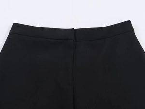 Detailed view of women's black high-waisted trousers with smooth waistband and hidden fly