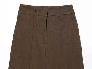 Detail of khaki wool blend trousers showing high waist, belt loops and sharp front pleats