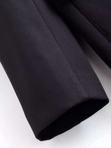 Detailed macro view of high-quality black twill fabric and fine stitching on dress sleeve