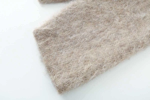 Close-up detail of soft camel jacquard knit fabric showing thick mohair texture and fiber weave