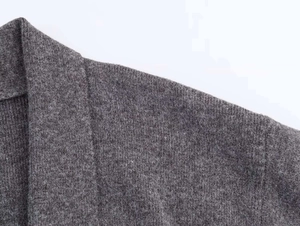 Detalle del cuello en V y la textura de punto de una chaqueta de cachemira gris oscuro