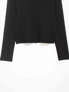 Vue détaillée d'un cardigan noir en maille avec boutons recouverts et bords côtelés