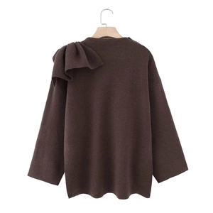 Detailed view of coffee knit sweater with large shoulder pleats and bow accent detail