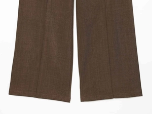 Detailed macro view of khaki wool blend pants featuring sharp center creases and fine texture