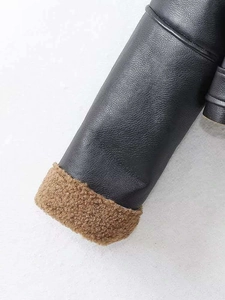 Detail of winter biker jacket with black leather outer and warm brown faux shearling cuff