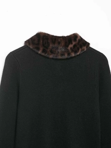 Détail d'un cardigan noir en maille avec un col élégant en fausse fourrure léopard