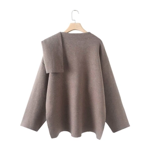 Detail view of khaki knit poncho sweater featuring asymmetric layered scarf collar design
