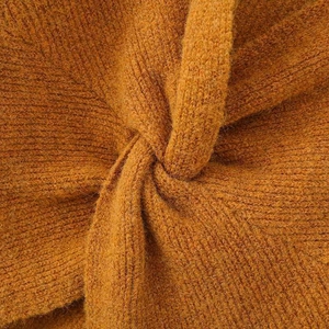 Fashionable ginger orange knit sweater featuring a stylish back knot detail and ribbed texture