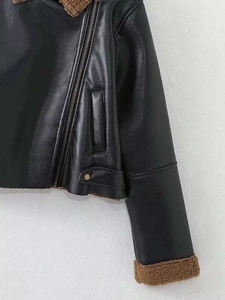 Detail of black faux leather biker jacket featuring brown sherpa fleece collar and cuff trim