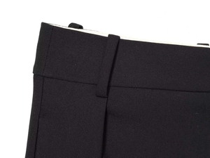 Detailed close-up of the waistband, belt loops and twill fabric on black trousers