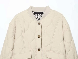 Detail of round quilted beige jacket featuring ribbed collar and leopard print lining