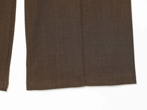 Detail of khaki green wool blend trousers showing clean hem and twill fabric texture