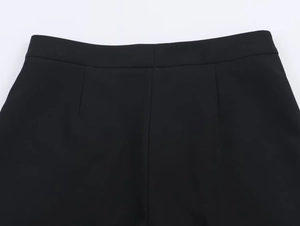 Close-up of black tailored trousers showing precise waistband stitching and waist darts