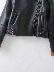 Close-up of black leather jacket with brown faux shearling lining and metal zipper