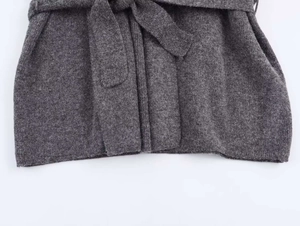 Primer plano de cárdigan de cachemira gris oscuro con cinturón de punto y textura acanalada