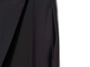 Detailed view of side pockets and fine twill fabric on black wide-leg trousers