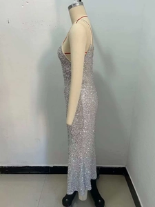 Detail of silver sequin slip dress featuring shimmering metallic fabric and low back cut