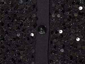Detailansicht der schwarzen Paillettenstrickjacke mit gerippter Blende und Knopf