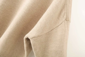 Detail of the high-quality shoulder seam and beige fine knit texture on this sweater