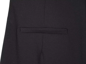 Macro shot of precise welt pocket and twill texture on black wide-leg trousers