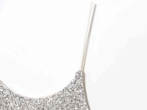 Close-up of silver sequin dress detailing shimmering texture and thin spaghetti strap