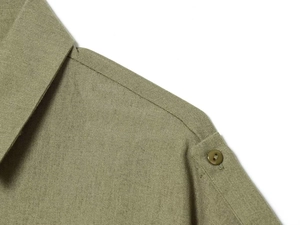 Close-up of olive green casual jacket featuring textured fabric and buttoned epaulette