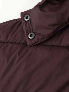 Close-up of neckline and star-embossed black metal buttons on a burgundy puffer jacket